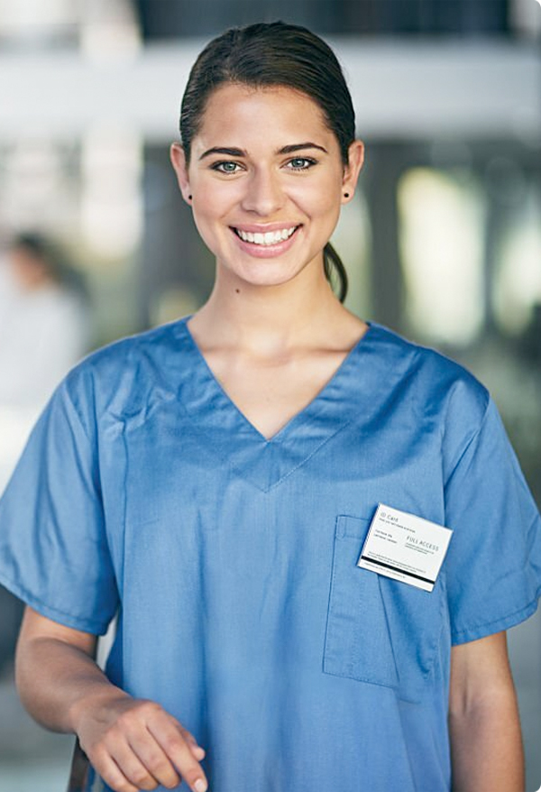 A smiling nursing student in blue scrubs